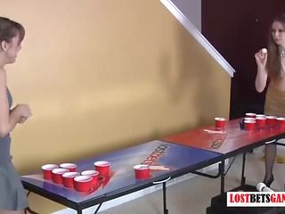 Two perky girls play strip beer pong
